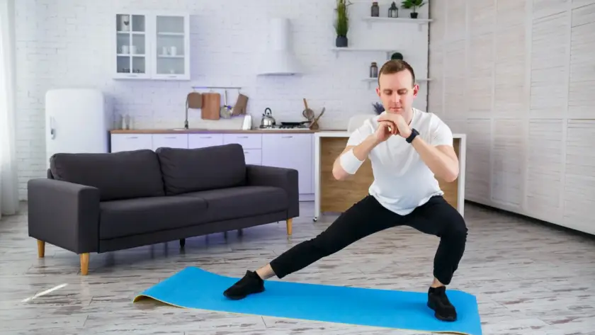 Beginner doing warm-up stretches before starting HIIT workout at home
