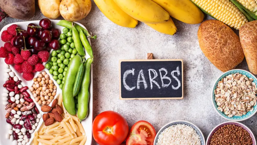 A plate of whole grain foods, fruits, and vegetables, symbolizing healthy carbohydrates.