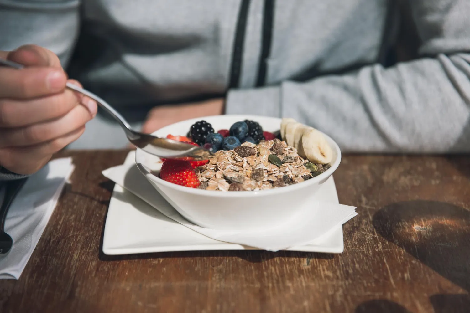 A nutritious high-protein breakfast spread featuring eggs, avocado, Greek yogurt, berries, and whole grain toast on a wooden table, ideal for weight loss.