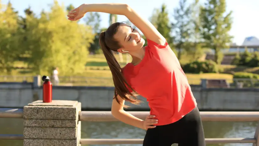 Girl stretching her body outdoors as part of a morning exercise routine for energy and focus.