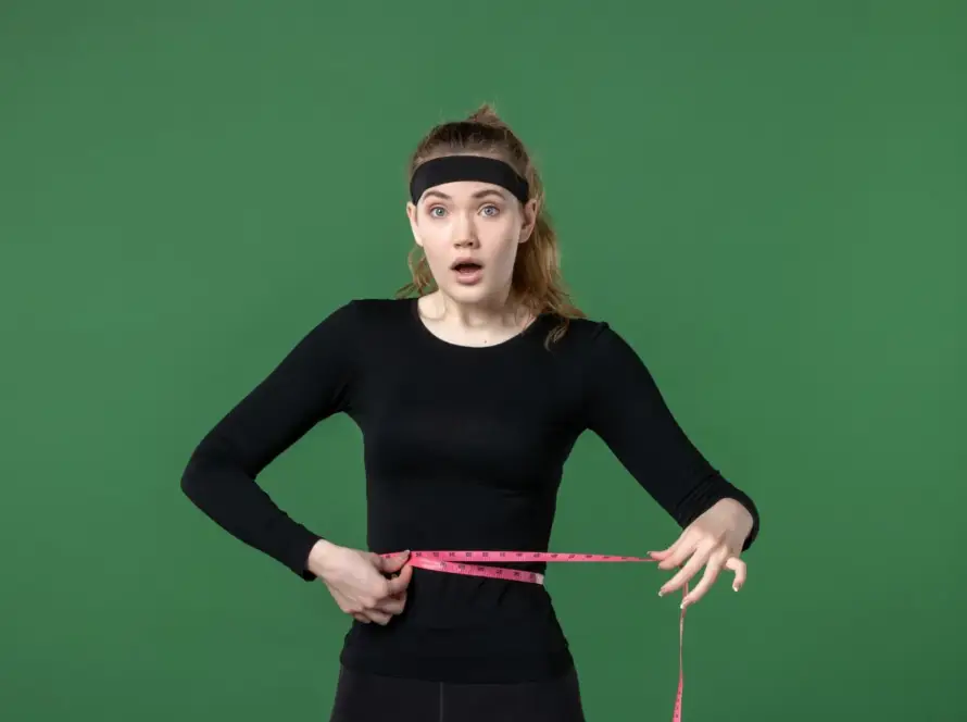 A person working out outdoors with a positive expression, symbolizing weight loss and a healthy lifestyle.