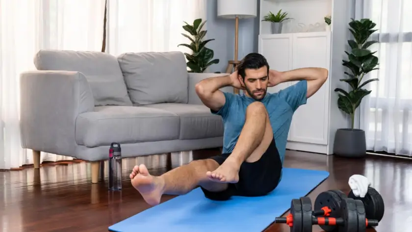 Man doing core exercises at home during HIIT workout for weight loss.