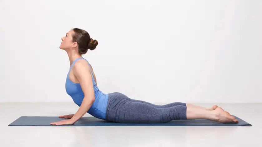 Young woman performing Cobra Pose to strengthen and stretch her spine for a Pain-Free Human Back
