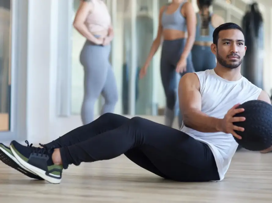 Energetic man and woman doing HIIT workouts for weight loss in a modern gym.