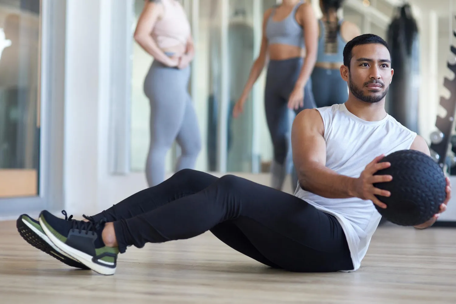 Energetic man and woman doing HIIT workouts for weight loss in a modern gym.