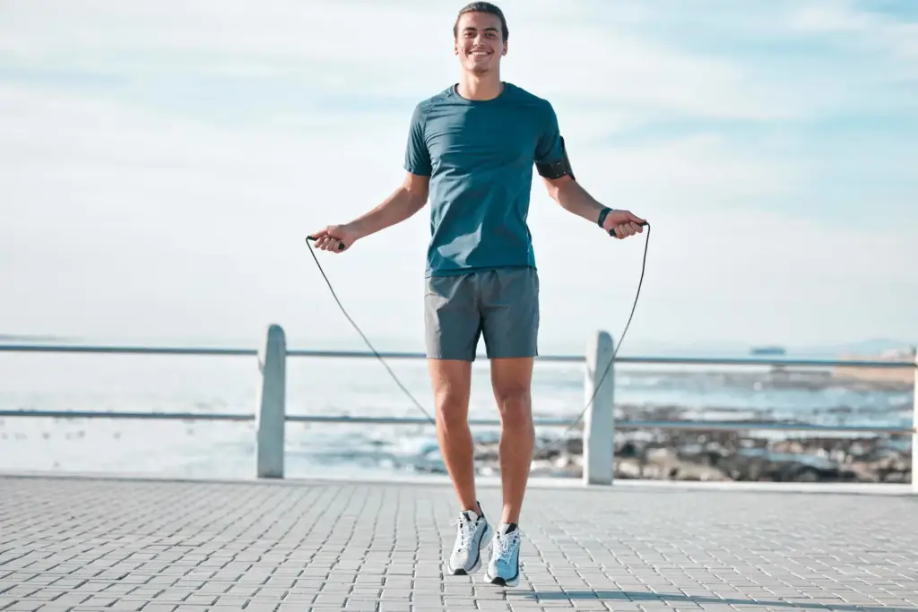 A men jumping rope outdoors as part of an effective fat-burning workout.