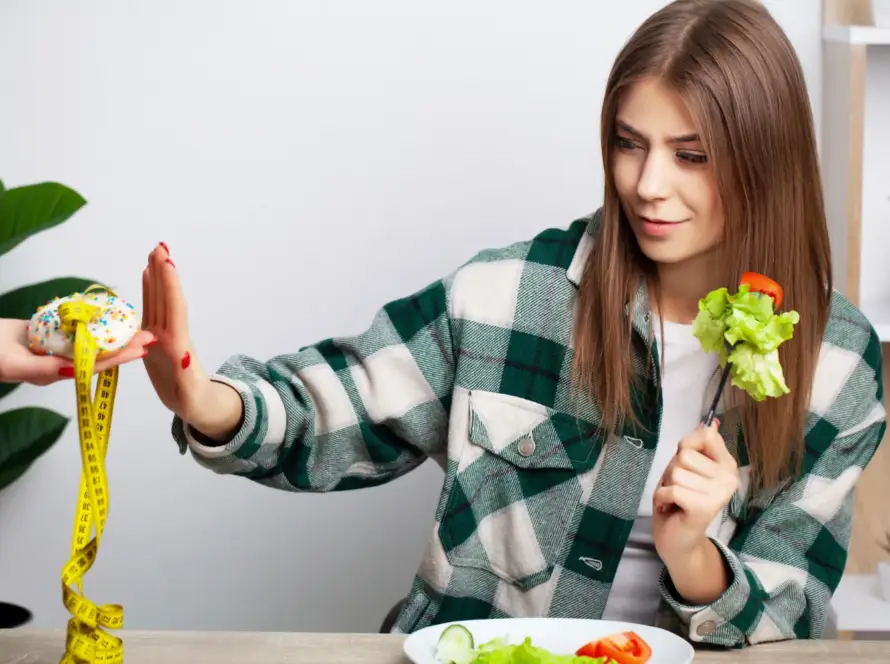 Person measuring calories and eating a healthy meal to maintain a calorie deficit for weight loss