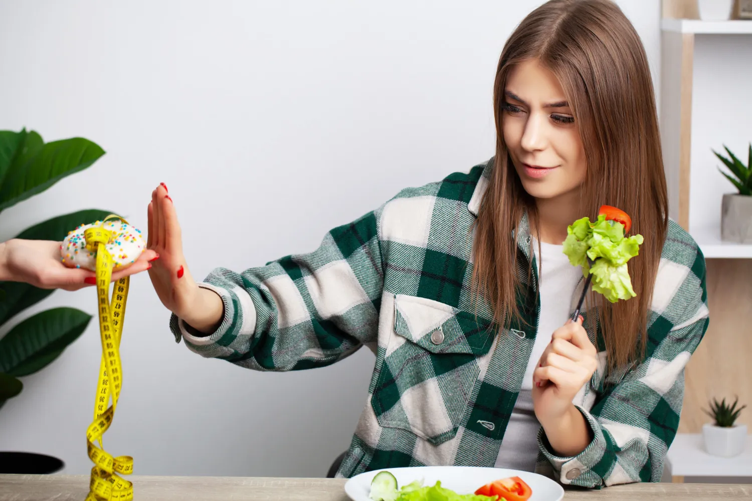 Person measuring calories and eating a healthy meal to maintain a calorie deficit for weight loss
