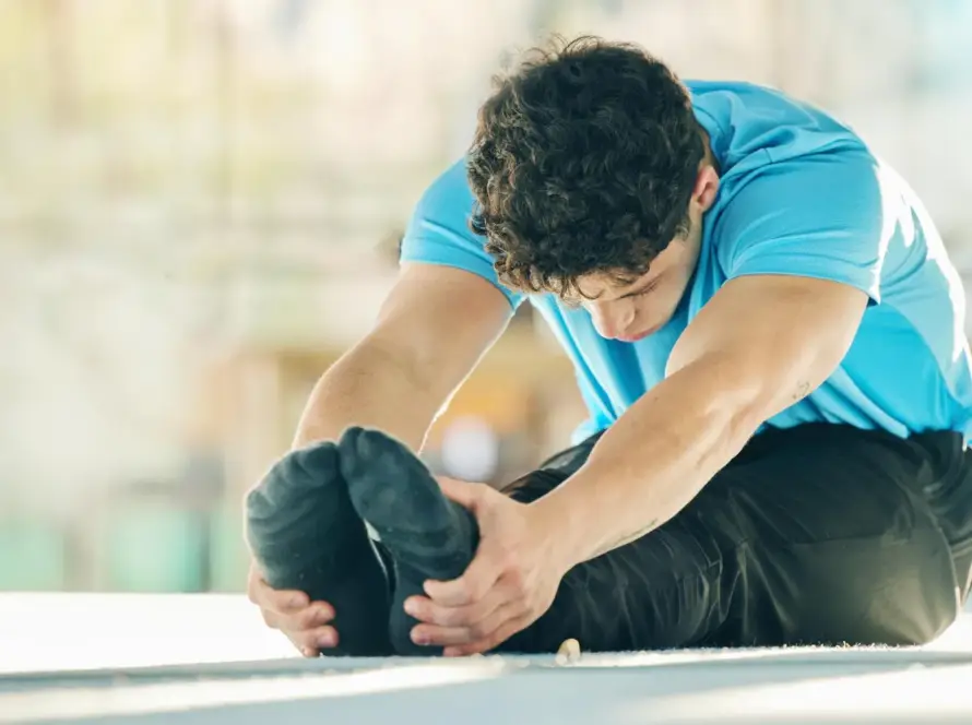 Sports Injury Recovery Exercises at Home with athlete doing gentle knee rehabilitation stretch in living room