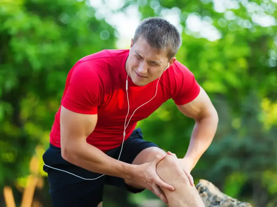 Natural sports injury recovery showing athlete resting and stretching injured leg
