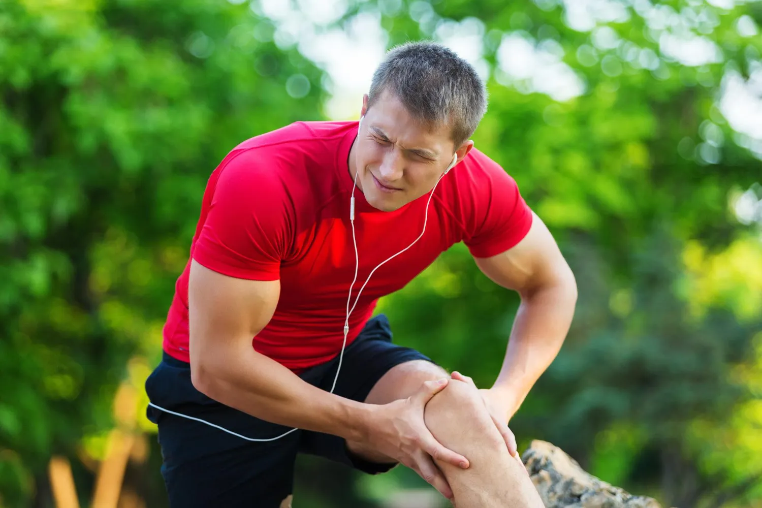Natural sports injury recovery showing athlete resting and stretching injured leg